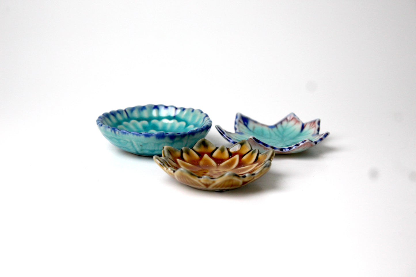 Ceramic tiny plates shaped like autumn maple leaves in blue and brown color.