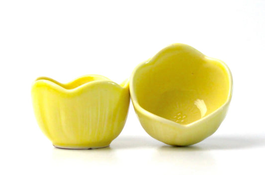 Two yellow ceramic sake cups shaped like camellia flower