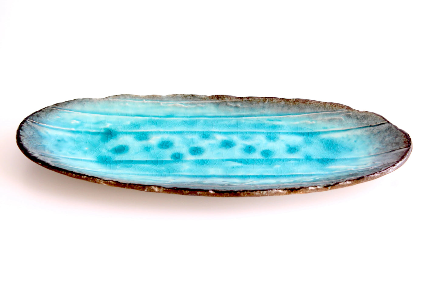 A handcrafted ceramic snack platter with a glossy Miyako blue glaze, inspired by a banana leaf texture, with organic brown-edged detailing.