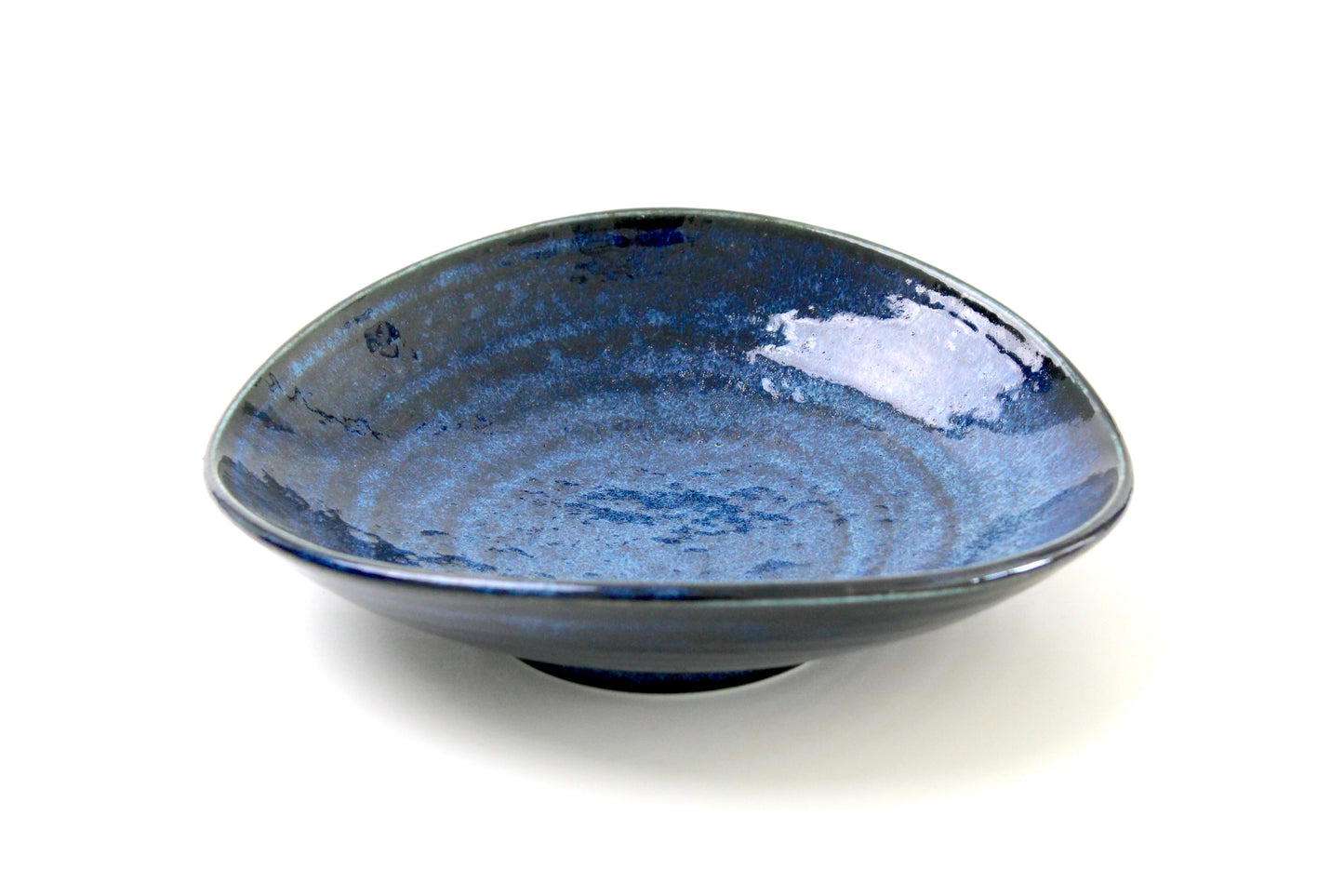 A handcrafted Japanese ceramic bowl in a stunning midnight blue glaze with a glossy, textured finish. The shallow, wide design adds elegance, making it perfect for luxury dinnerware collections.