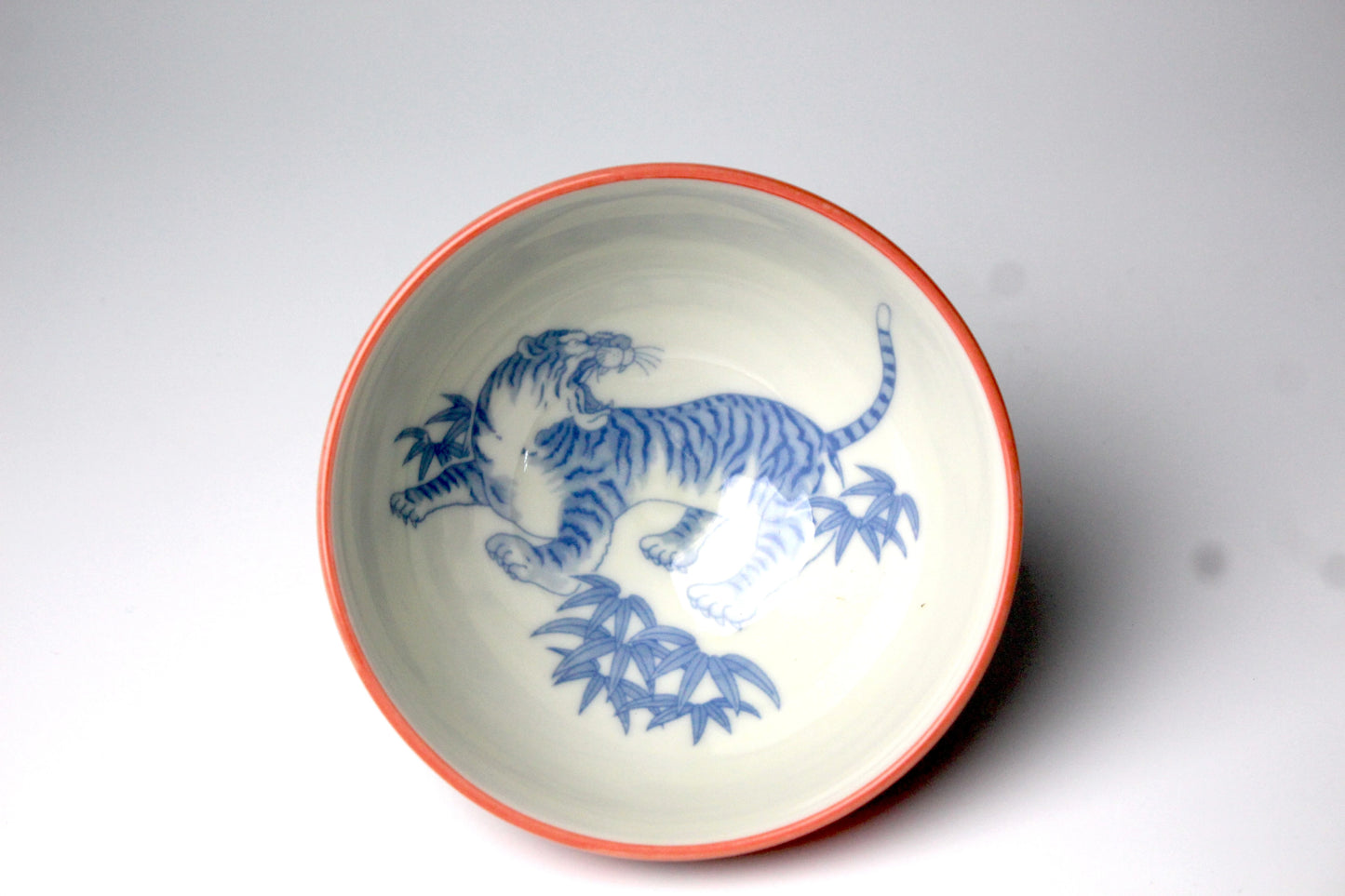 Traditional Japanese rice bowl with a roaring tiger in blue imprinted inside