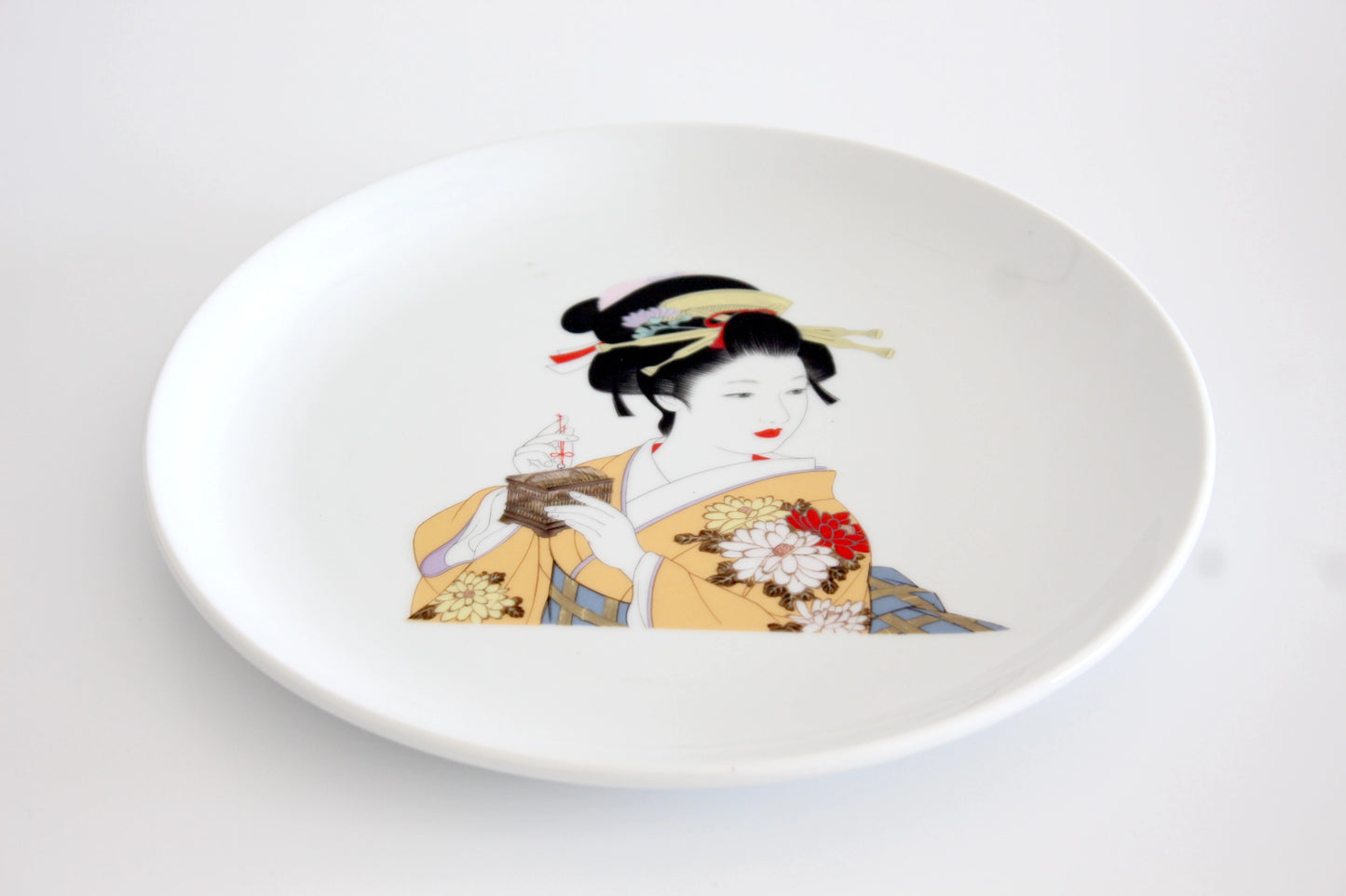 11-inch porcelain dinner plate featuring an elegant geisha in a yellow kimono, adorned with intricate cherry blossom accents, microwave-safe.