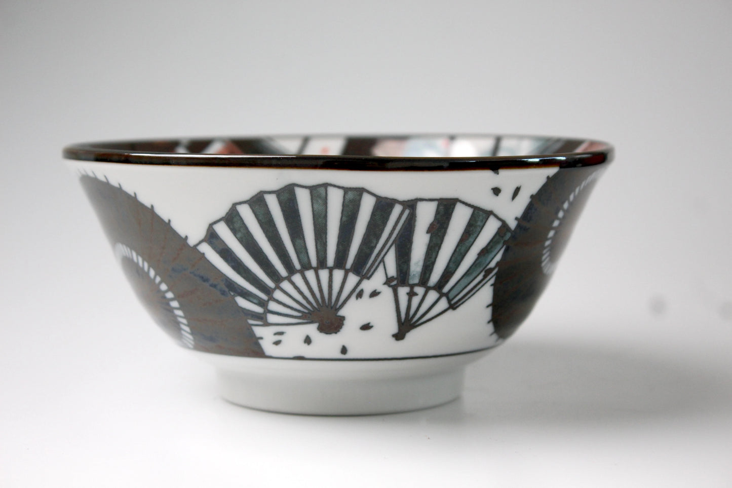 Japanese porcelain bowl featuring an intricate design of hand fans in black.