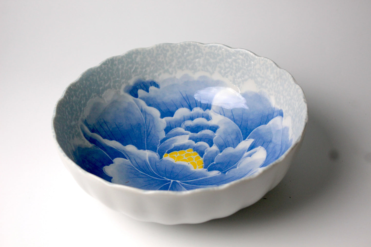A stunning blue ceramic bowl featuring a hand-painted peony flower design with intricate details and a glossy finish, perfect for elegant dining and serving.