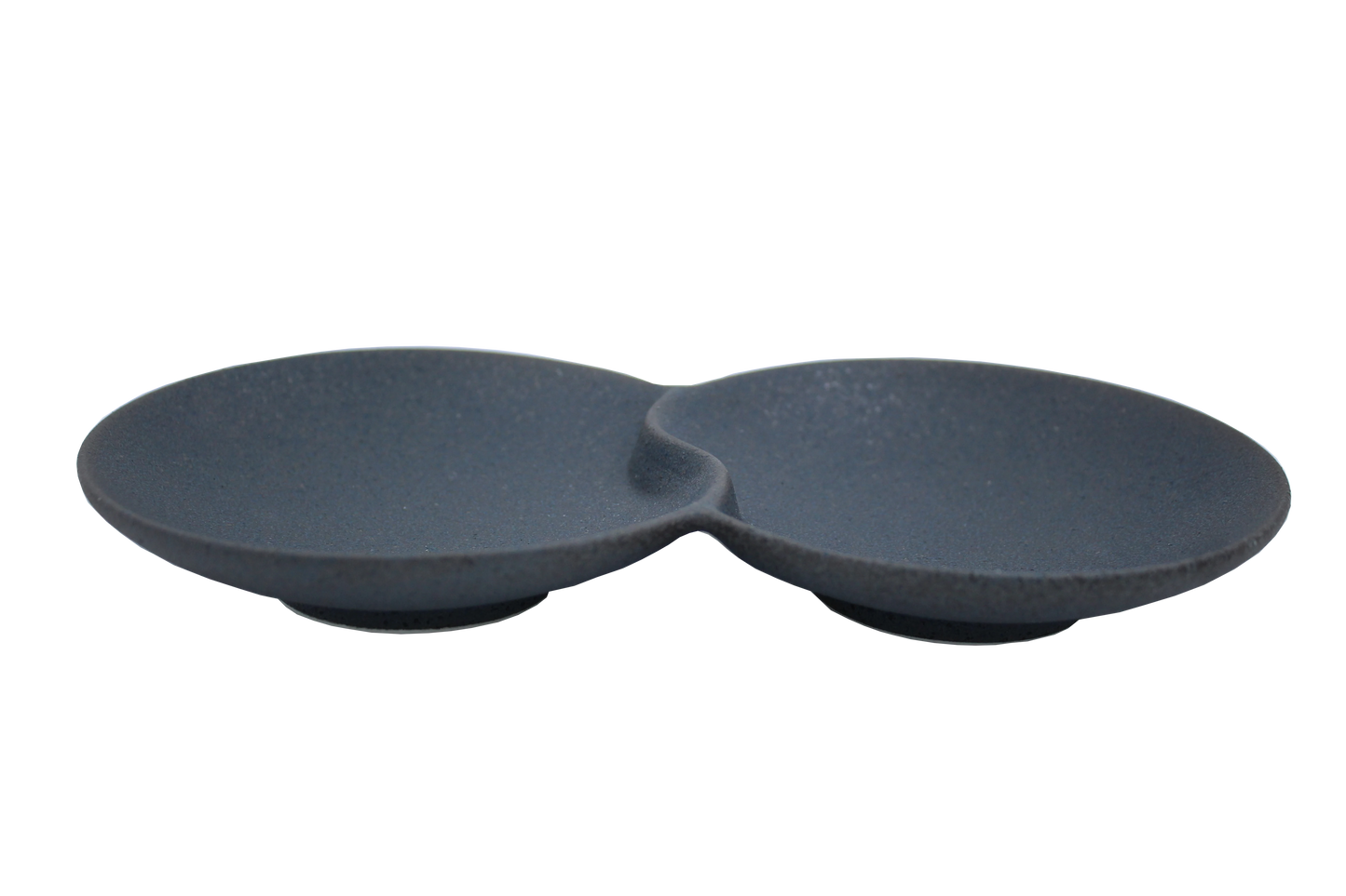 An isometric view of the Missera Hotate, a matte black ceramic divided serving dish with two circular sections joined in the center like a clam shell. Perfect as a multi compartment serving dish for snacks and dips.