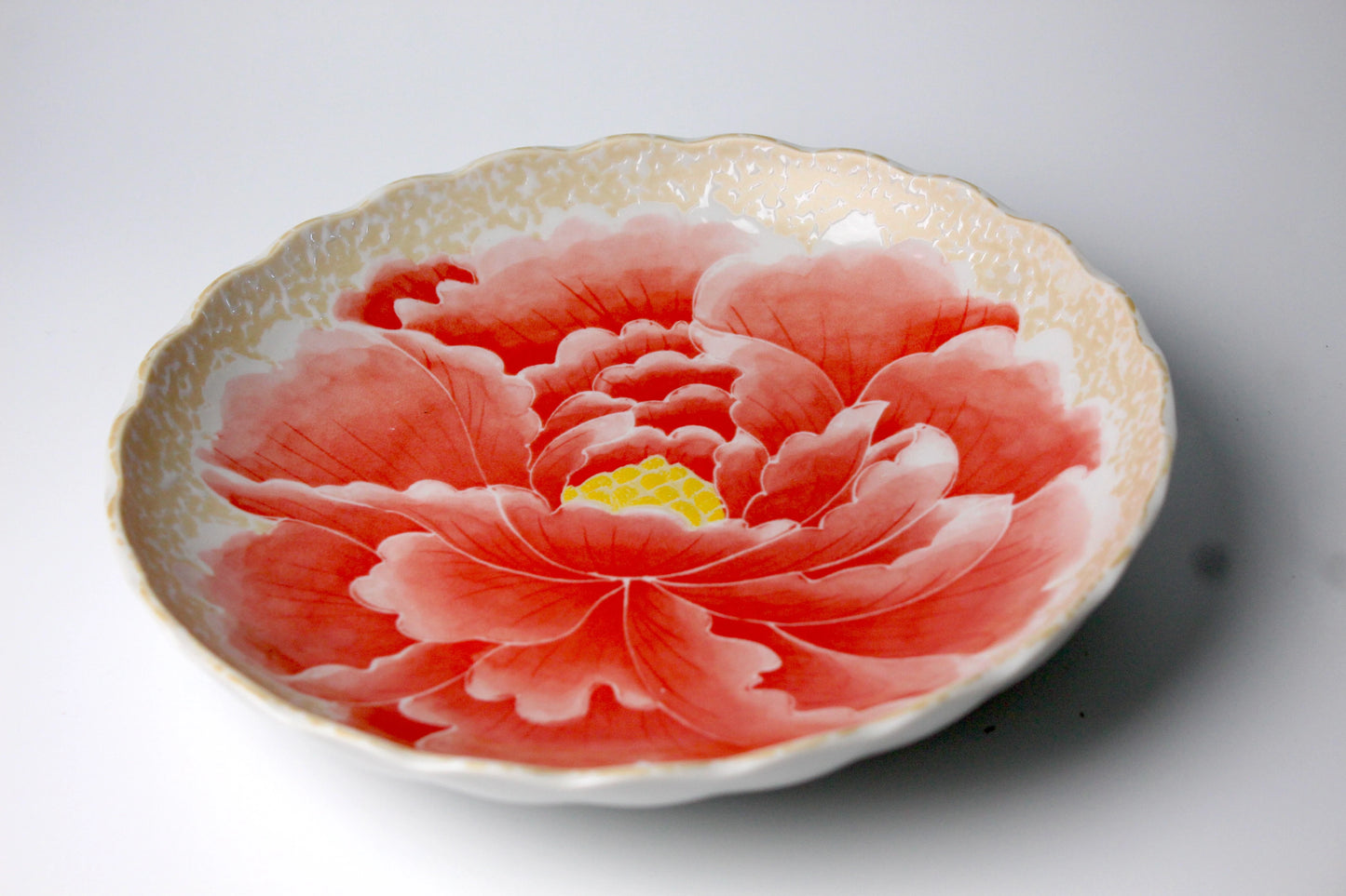 A beautifully crafted red ceramic dining plate featuring a hand-painted peony flower design with delicate gold accents, ideal for sophisticated dining and serving.
