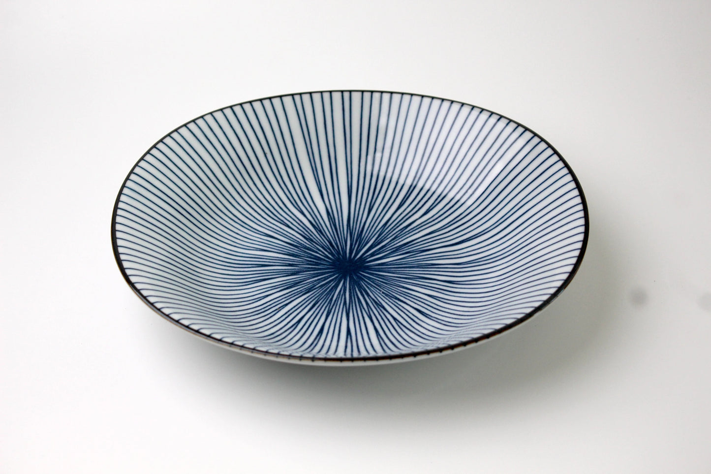 A Japanese porcelain plate in Saikai style, featuring the radial lines of a fan.