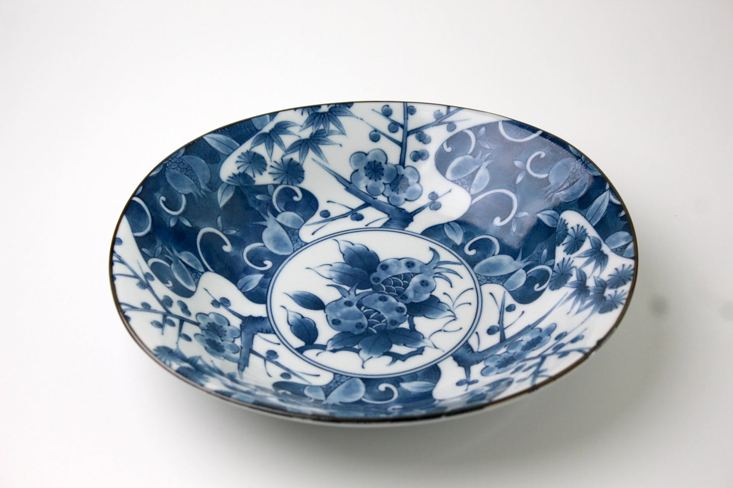 A beautifully crafted Japanese porcelain plate in Saikai style, featuring intricate blue floral and botanical patterns inspired by traditional Arita and Imari ceramics.