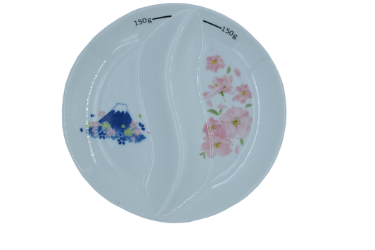 Top-down view of a white two sectional thali or divided plate with 150g markings, featuring Mount Fuji & cherry blossoms designs