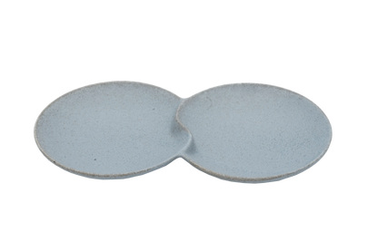 An isometric view of the Missera Hotate, a light gray ceramic divided serving dish with two circular sections joined in the center like a clam shell. Perfect as a multi compartment serving dish for snacks and dips.